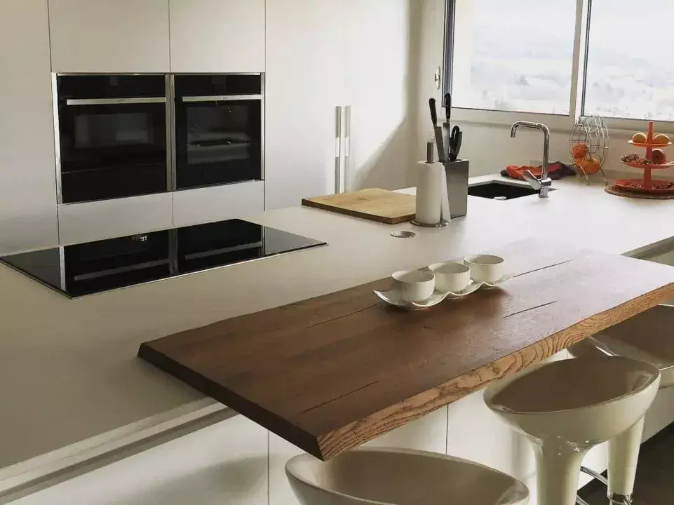 Zoom sur cuisine moderne de couleur blanche avec son plan de travail en bois, tasses, couteaux et robinet / design par ViolaDeco, Iana Viola