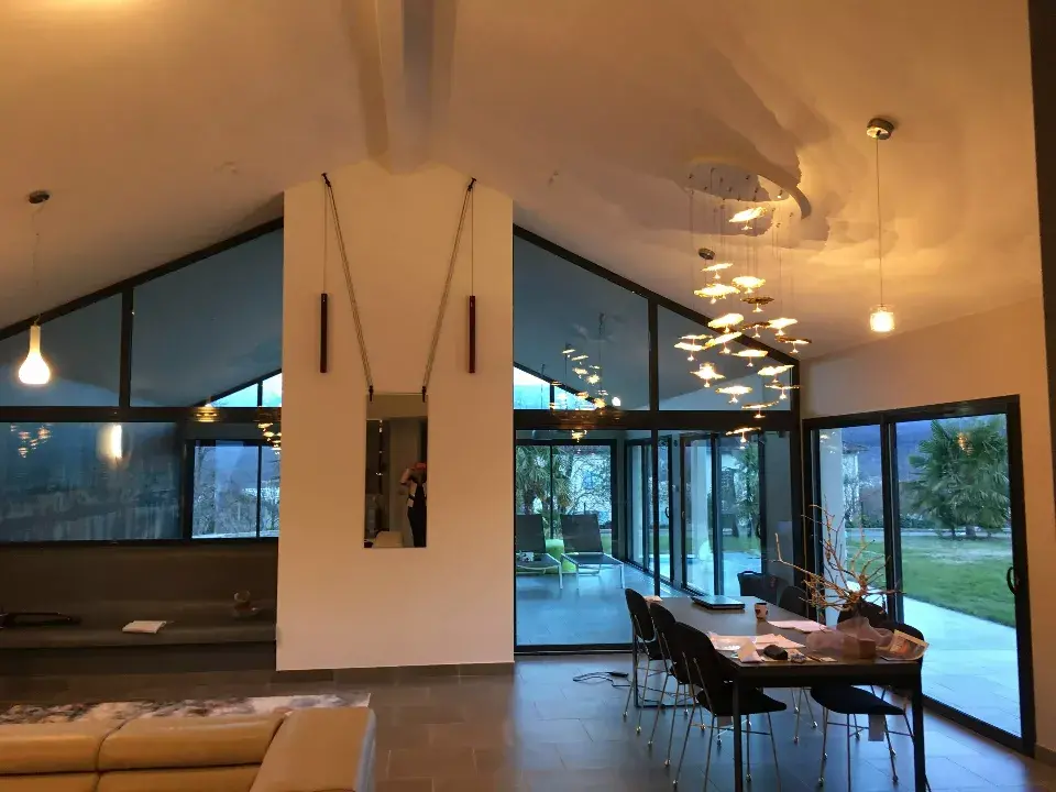 Salon design d'une villa avec luminaires elegants creant des effets de lumieres, miroir, table, canape et magnifique veranda / decoration par ViolaDeco, Iana Viola